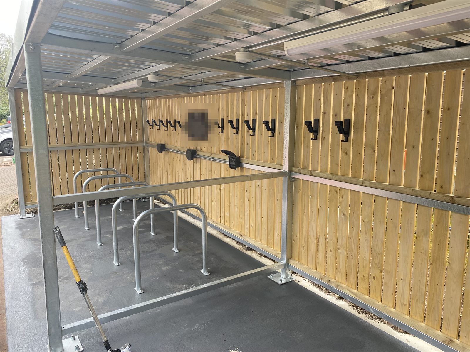 New covered cycle shelter with timber-clad walls, Sheffield stands and wall-mounted racks