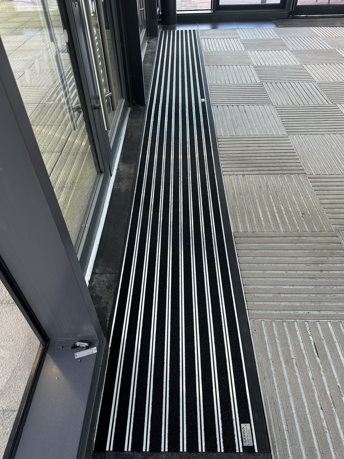Recessed entrance matting set into wood-effect flooring at a doorway