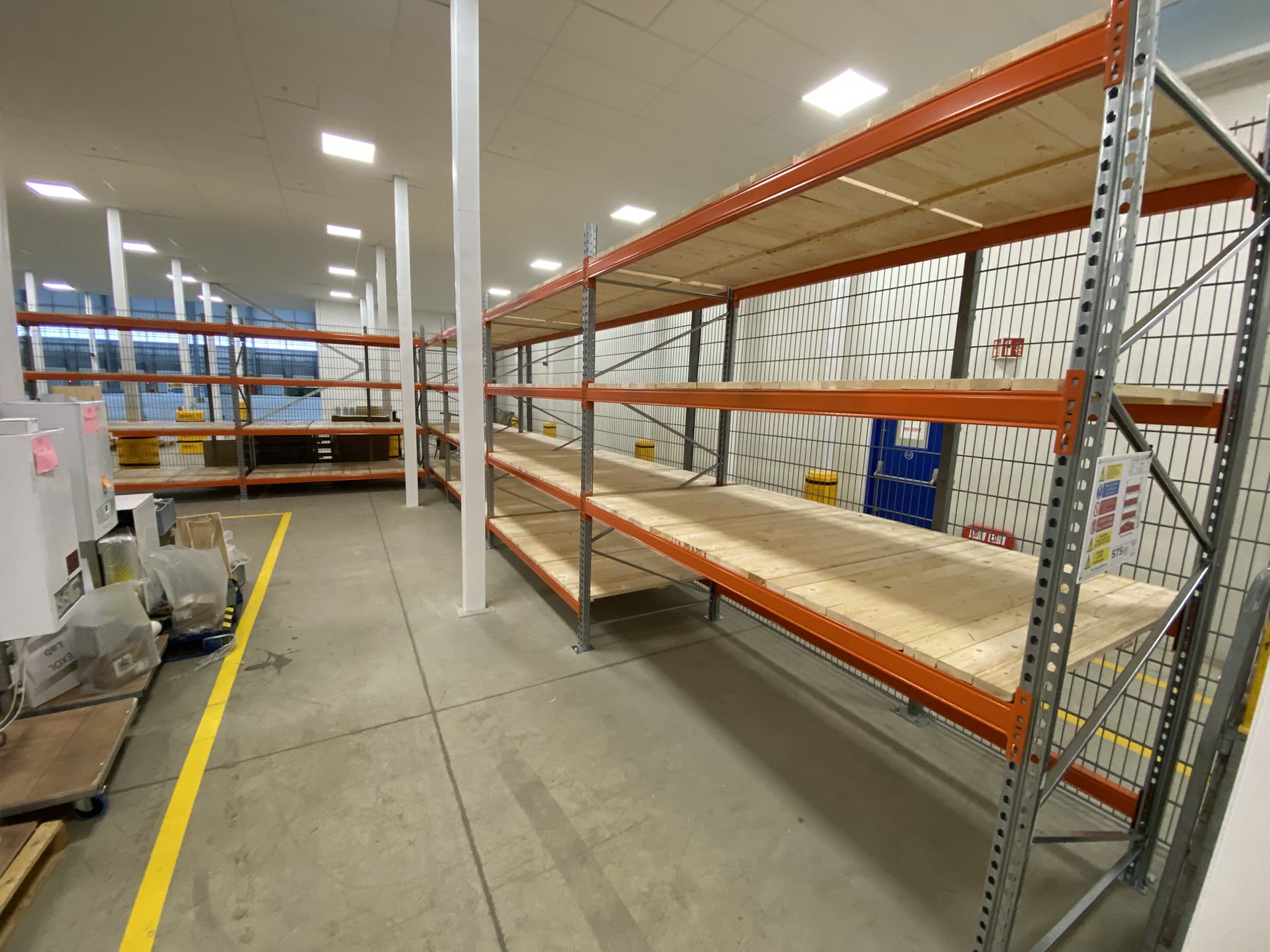 Pallet racking bays installed along warehouse wall