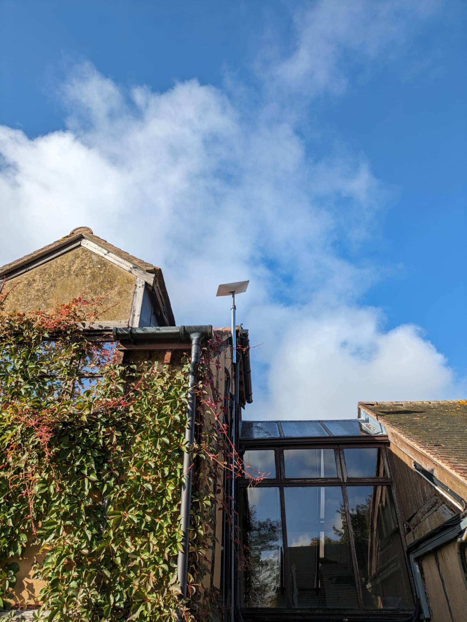 Starlink satellite dish installed on a pole at roof level