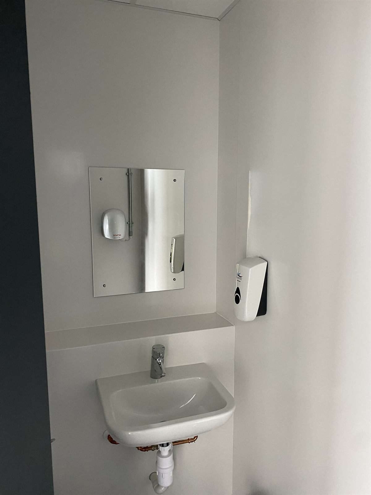 Refurbished washroom with new hygienic wall cladding and basin